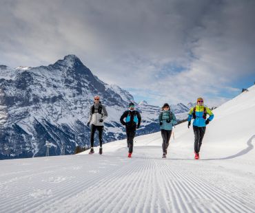 4 people running at high altitude snowy trail 4 people running at high altitude snowy trail