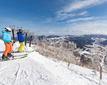 Two Skiers overlooking Tomamu ski resort Two Skiers overlooking Tomamu ski resort